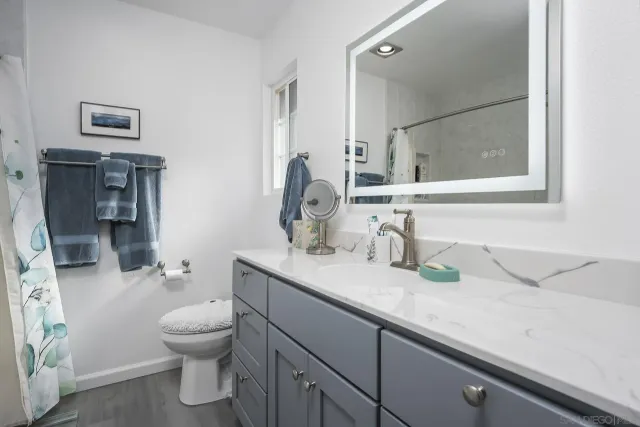 a bathroom with a granite countertop sink mirror and toilet