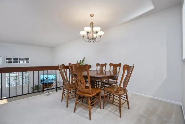 a dining room with furniture a chandelier and a window