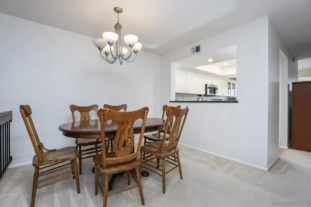 a dining room with wooden floor a chandelier a wooden table and chairs