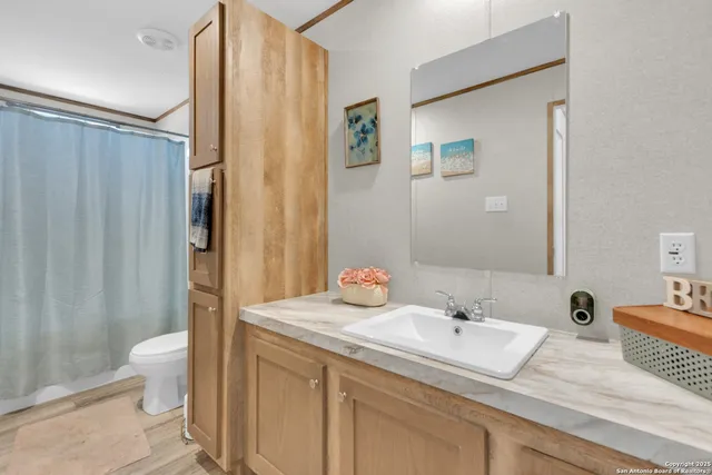 a en suite bathroom with a granite countertop sink toilet and shower