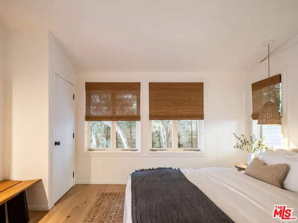 a living room with furniture a large window and wooden floor