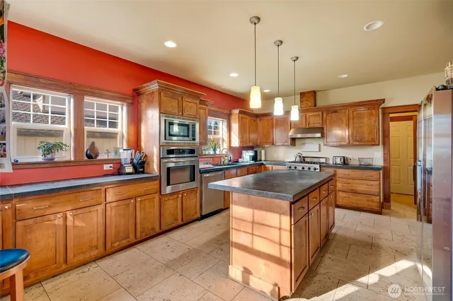 a kitchen with stainless steel appliances granite countertop a stove a sink and a refrigerator