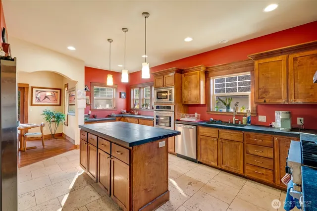 a kitchen with stainless steel appliances granite countertop a sink counter space and a large window