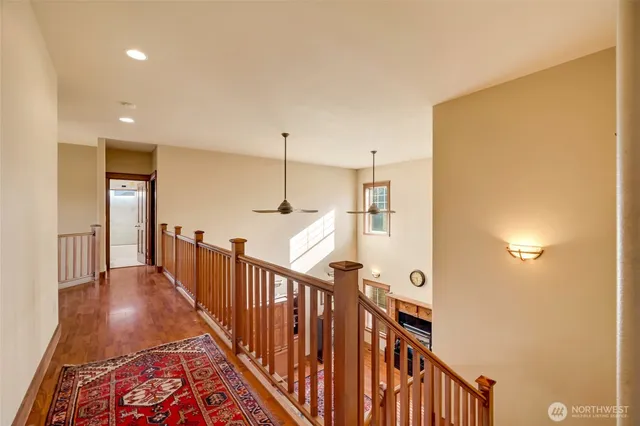 a view of a hallway with wooden floor and stairs