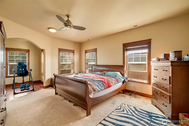 a spacious bedroom with a bed and wooden floor