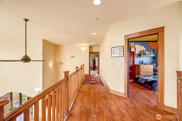 a view of a hallway with wooden floor and stairs