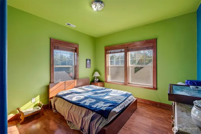 a bedroom with a bed and wooden floor