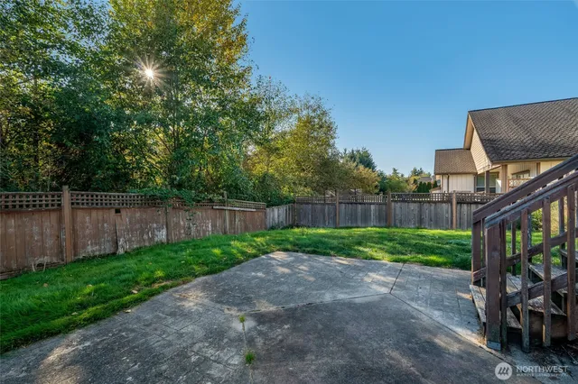 a view of a backyard with plants and wooden fence
