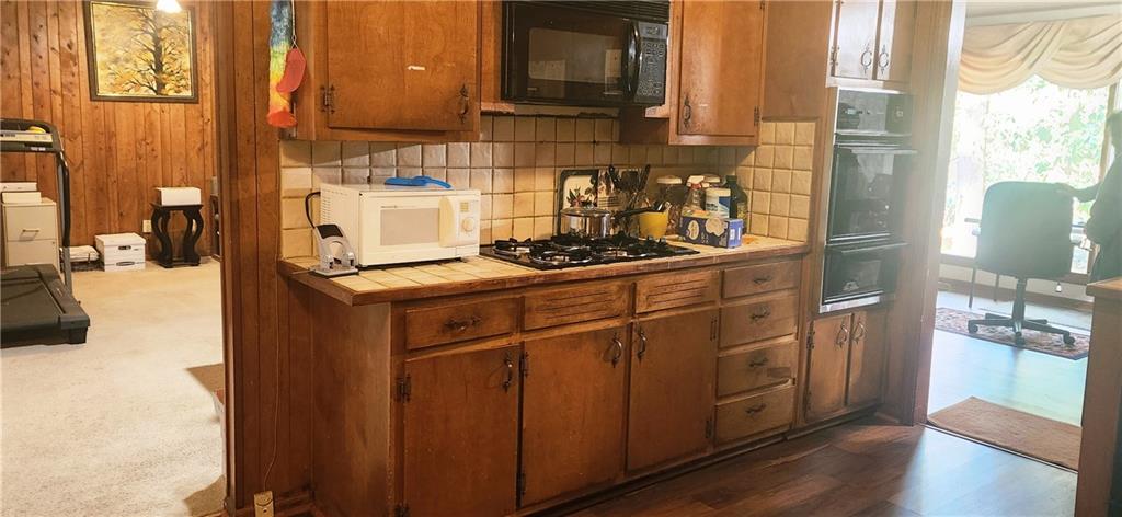 3140 Flat Shoals Road Atlanta, GA 30349 - Photo 7 of 16 a kitchen with stainless steel appliances granite countertop a sink stove and wooden cabinets