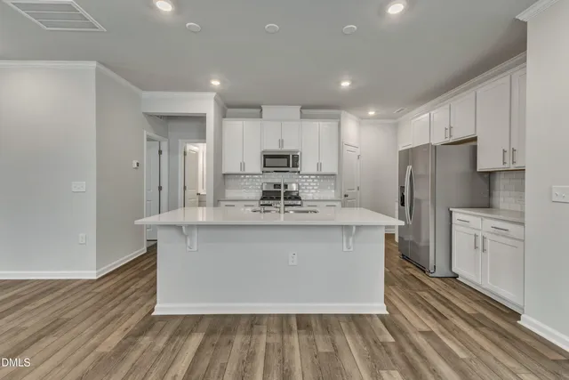 a kitchen with stainless steel appliances granite countertop a stove a sink and a refrigerator
