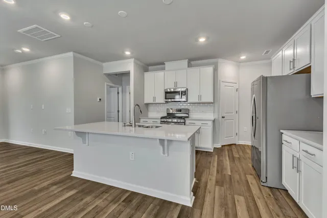 a kitchen with kitchen island a sink stainless steel appliances and cabinets