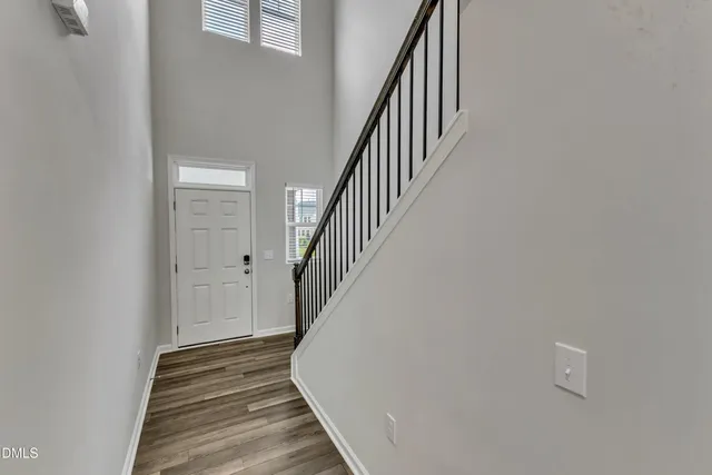 a view of a hallway with wooden floor and staircase