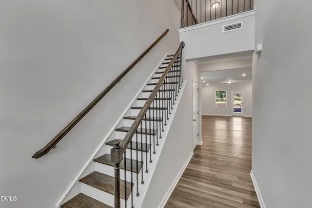 a view of a hallway with wooden floor and staircase