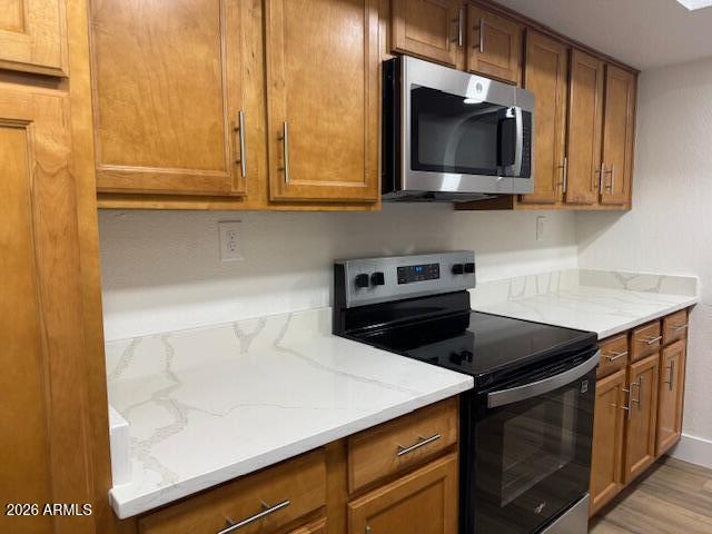 3825 East Camelback Road, Unit 226 Phoenix, AZ 85018 - Photo 10 of 20 a kitchen with stainless steel appliances a stove a microwave and white cabinets