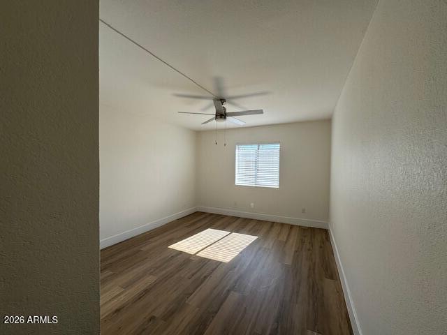 3825 East Camelback Road, Unit 226 Phoenix, AZ 85018 - Photo 14 of 20 an empty room with wooden floor fan and windows