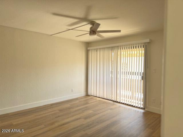 3825 East Camelback Road, Unit 226 Phoenix, AZ 85018 - Photo 17 of 20 an empty room with wooden floor fan and windows
