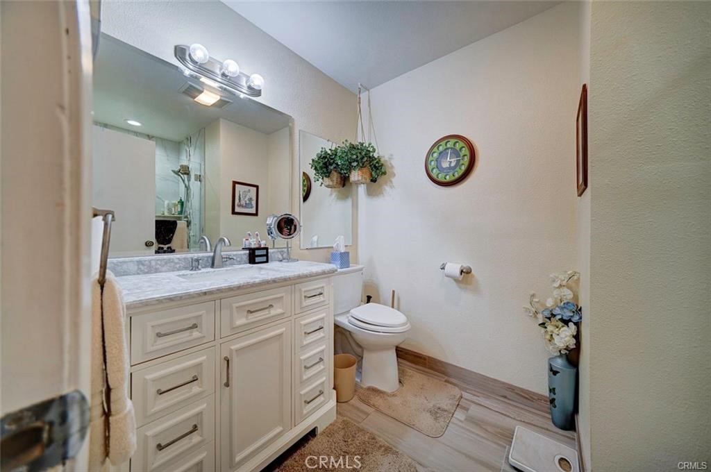 13556 La Jolla Circle, Unit 208H La Mirada, CA 90638 - Photo 13 of 39 a bathroom with a granite countertop toilet a sink and a mirror