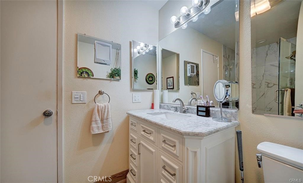 13556 La Jolla Circle, Unit 208H La Mirada, CA 90638 - Photo 14 of 39 a bathroom with a granite countertop sink a toilet and a mirror