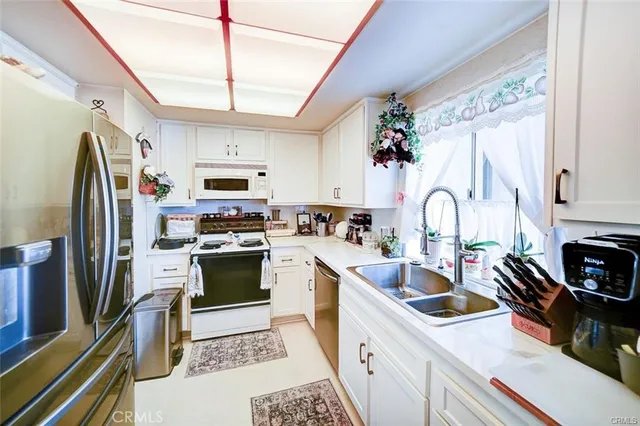 a kitchen with stainless steel appliances a stove sink refrigerator and cabinets