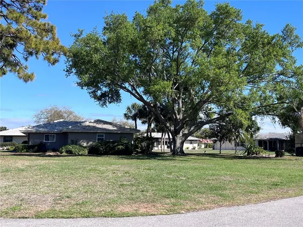 a front view of a house with a garden and trees