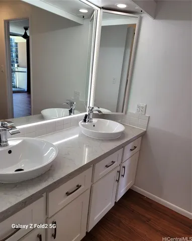 a bathroom with a granite countertop sink and a mirror