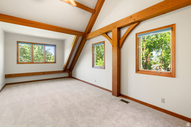 435 Canyon Road Millville, UT 84326 - Photo 35 of 113 Vaulted ceiling with exposed wood beams, multiple windows, light-toned carpeting, and wood window trim