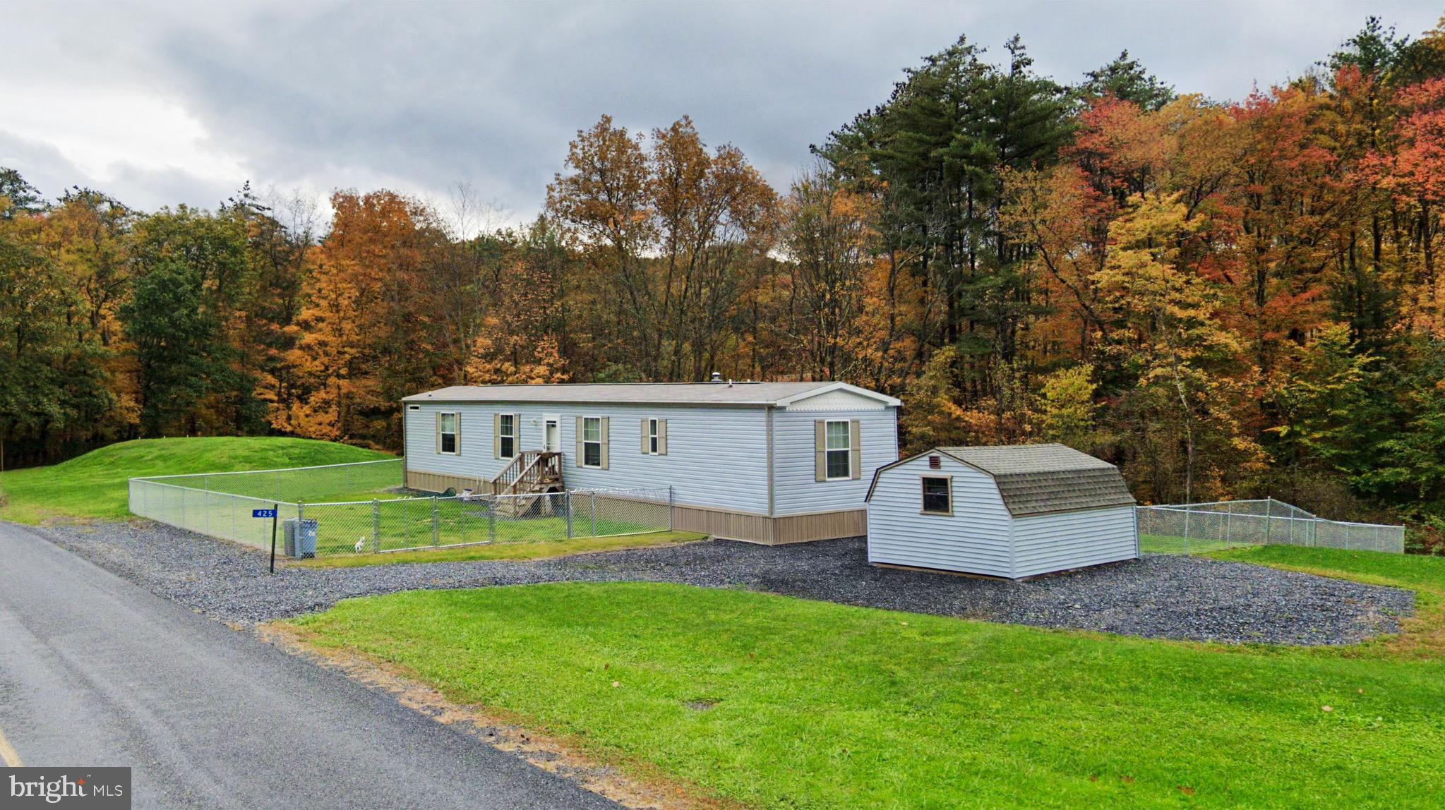 a view of a house with backyard and a tree