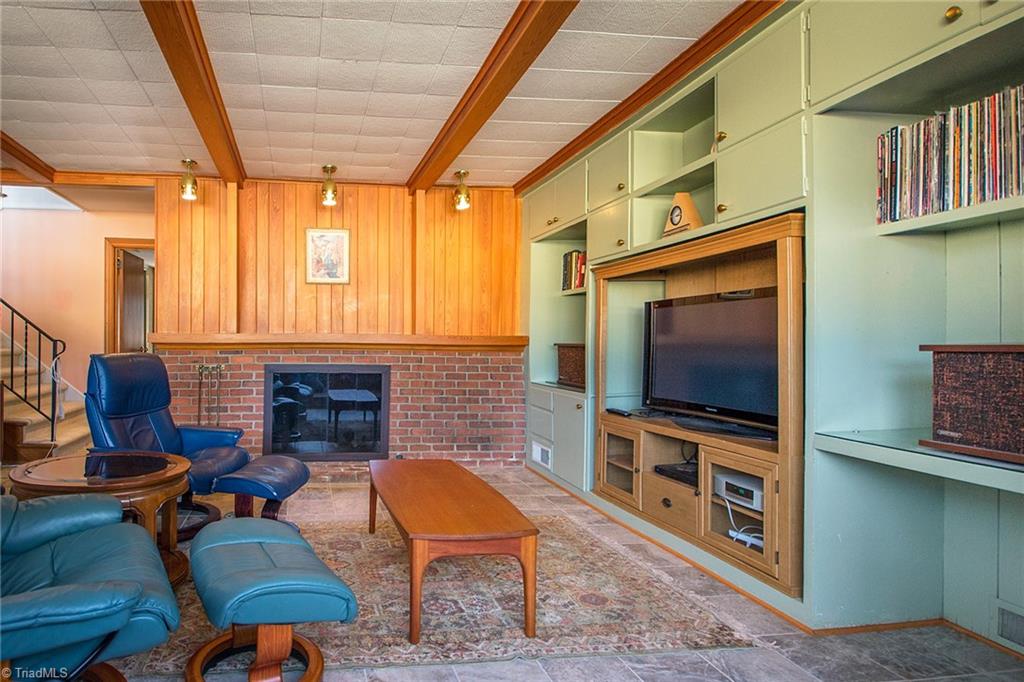3333 Nottingham Road Winston-Salem, NC 27104 - Photo 20 of 25 The lower level den has another fireplace, built-in shelving and brick-tile flooring.