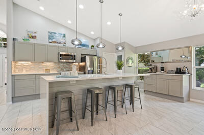 a kitchen with kitchen island granite countertop a table chairs sink and cabinets