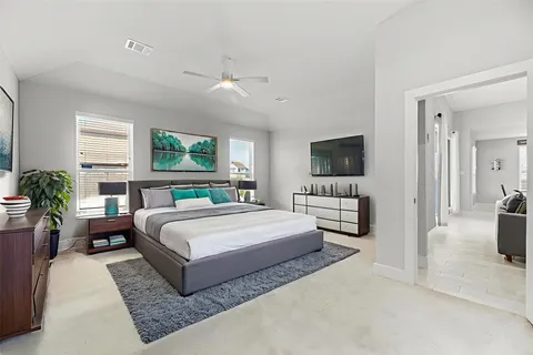 a spacious bedroom with a large bed a flat screen tv and a couch