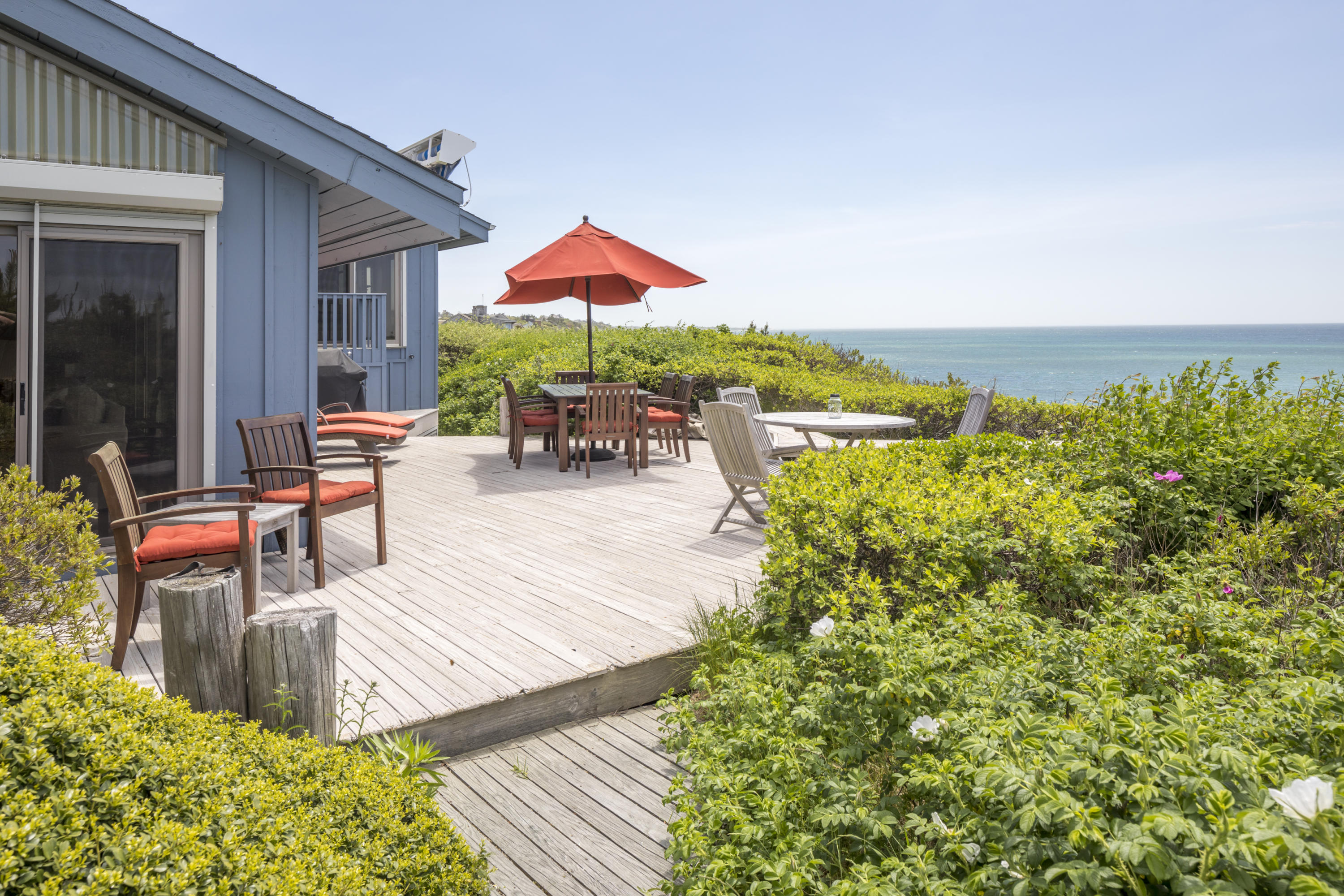 19 Avocet Road Truro, MA 02666 - Photo 20 of 26 a view of a patio with couches table and chairs under an umbrella