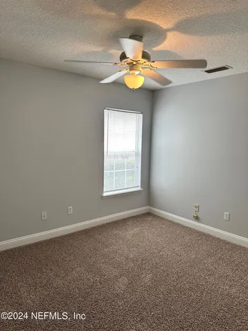 an empty room with a window and chandelier