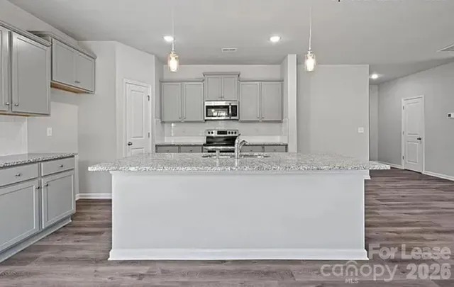 a kitchen with kitchen island granite countertop wooden cabinets and white appliances