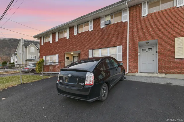 a car parked in front of a brick house