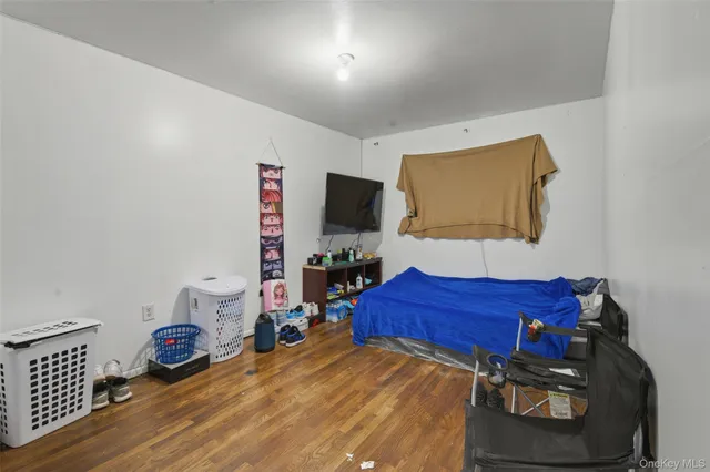 a bedroom with a bed and a flat tv screen on the dresser