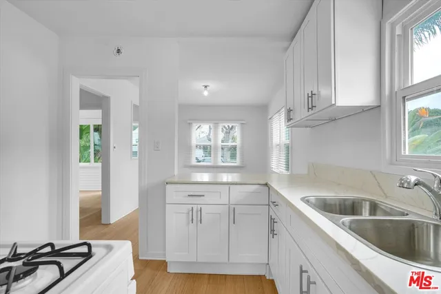 a kitchen with granite countertop a sink and cabinets