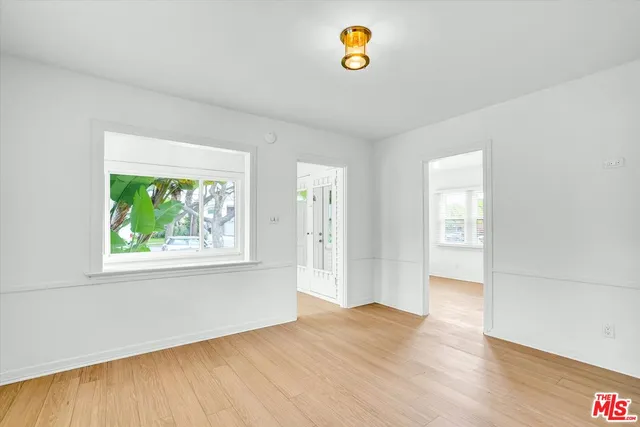 an empty room with window and wooden floor