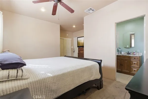 a bedroom with a bed and dresser with mirror