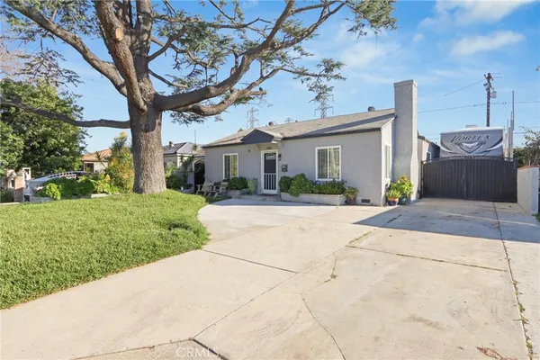a front view of a house with a yard and potted plants