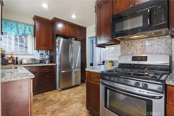 a kitchen with stainless steel appliances granite countertop a stove microwave and refrigerator