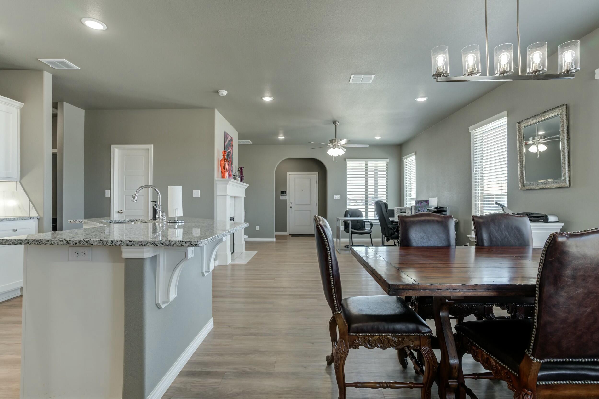 6928 11th Street Lubbock, TX 79416 - Photo 12 of 42 a dining room with stainless steel appliances kitchen island a table and chairs