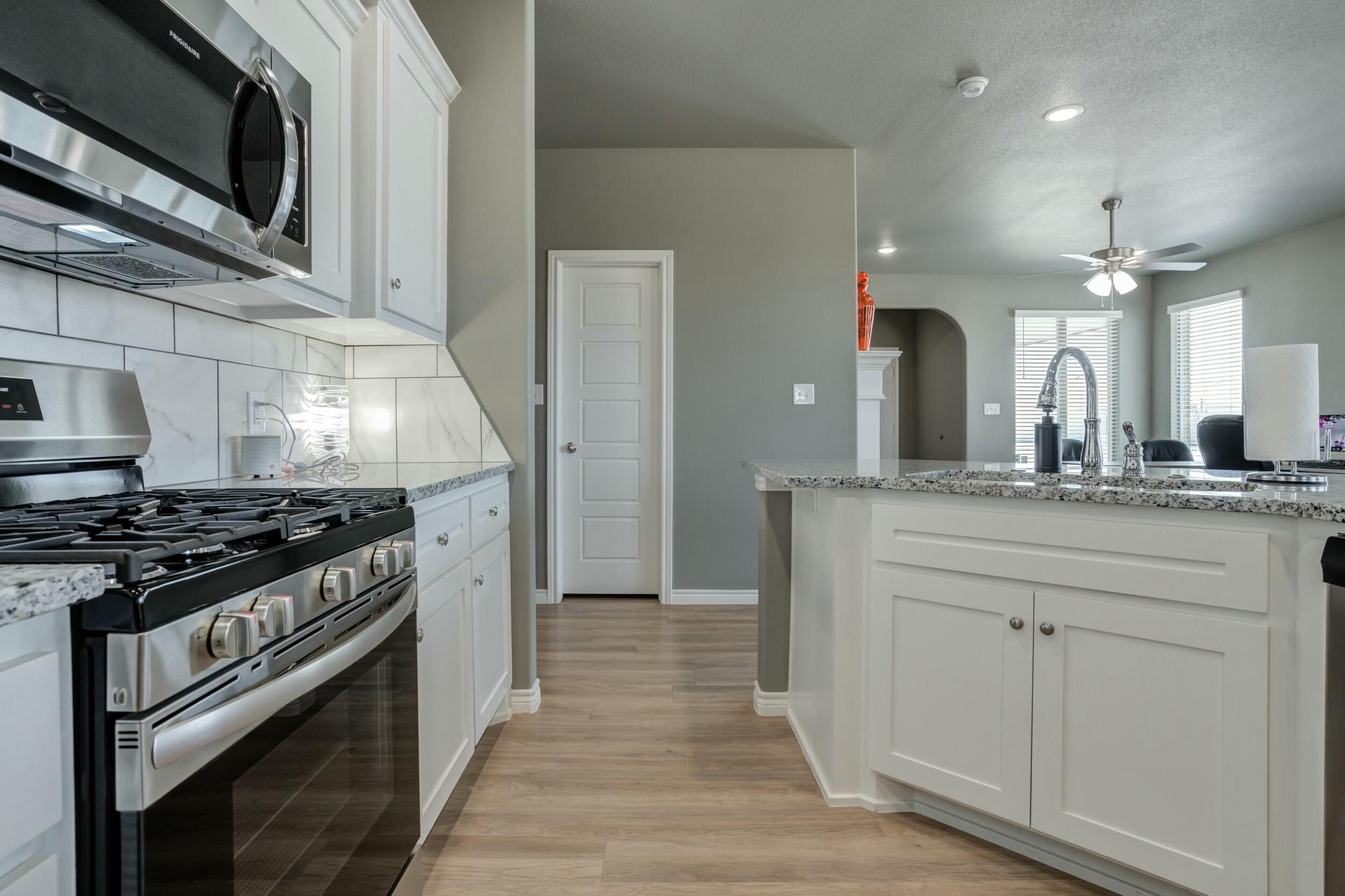 6928 11th Street Lubbock, TX 79416 - Photo 22 of 42 a kitchen with stainless steel appliances a stove and a microwave