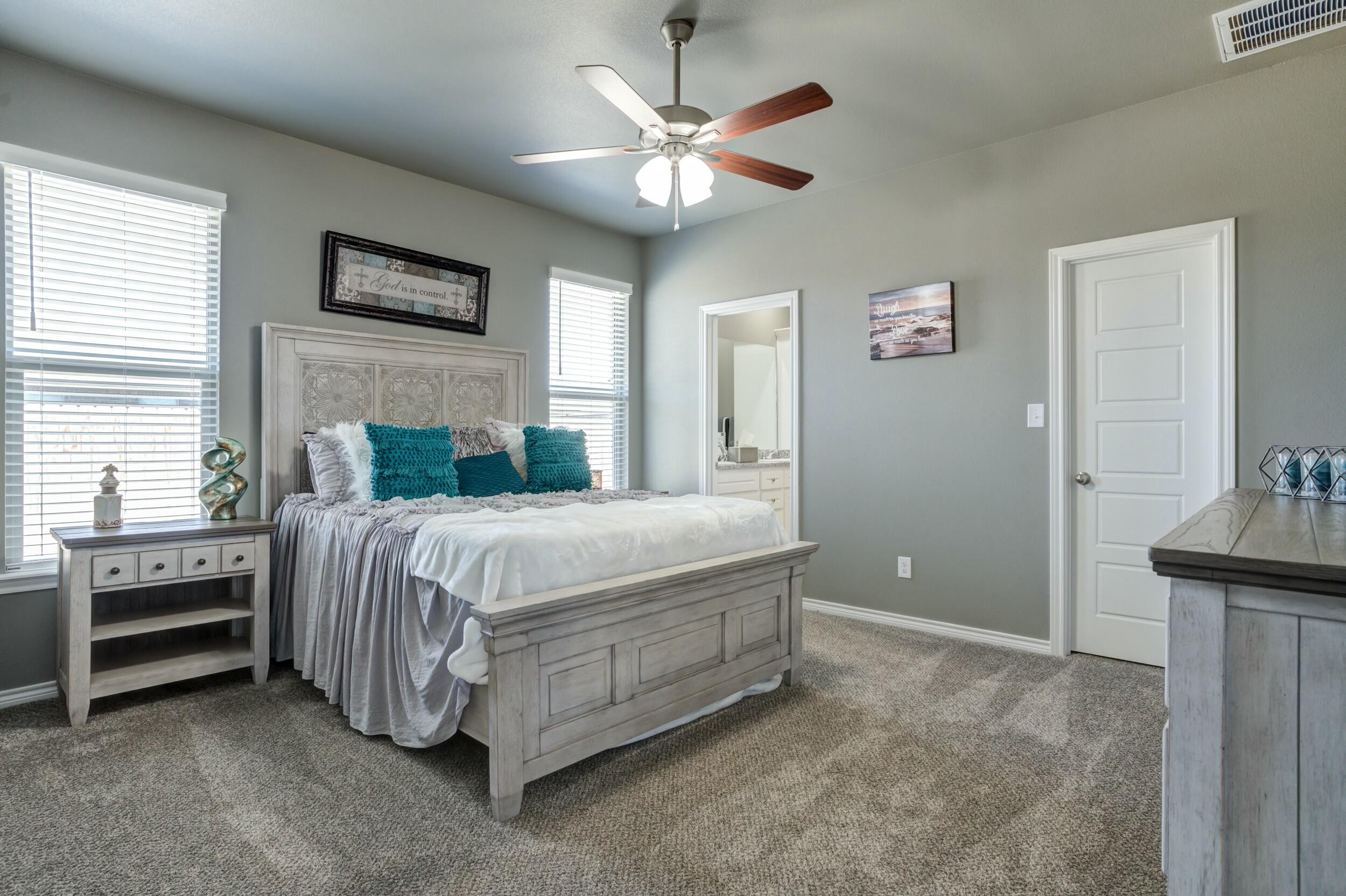 6928 11th Street Lubbock, TX 79416 - Photo 25 of 42 a bedroom with a bed and a ceiling fan