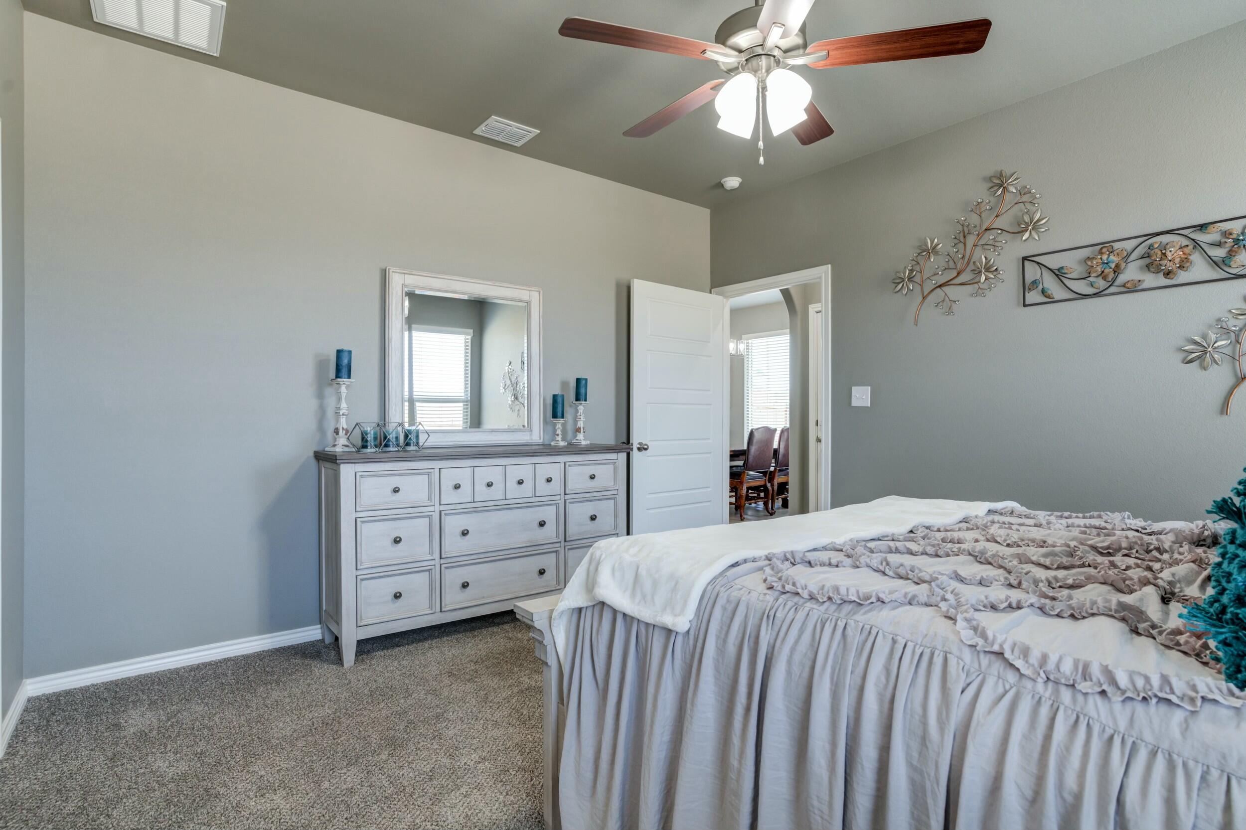 6928 11th Street Lubbock, TX 79416 - Photo 26 of 42 a bedroom with a bed and a dresser