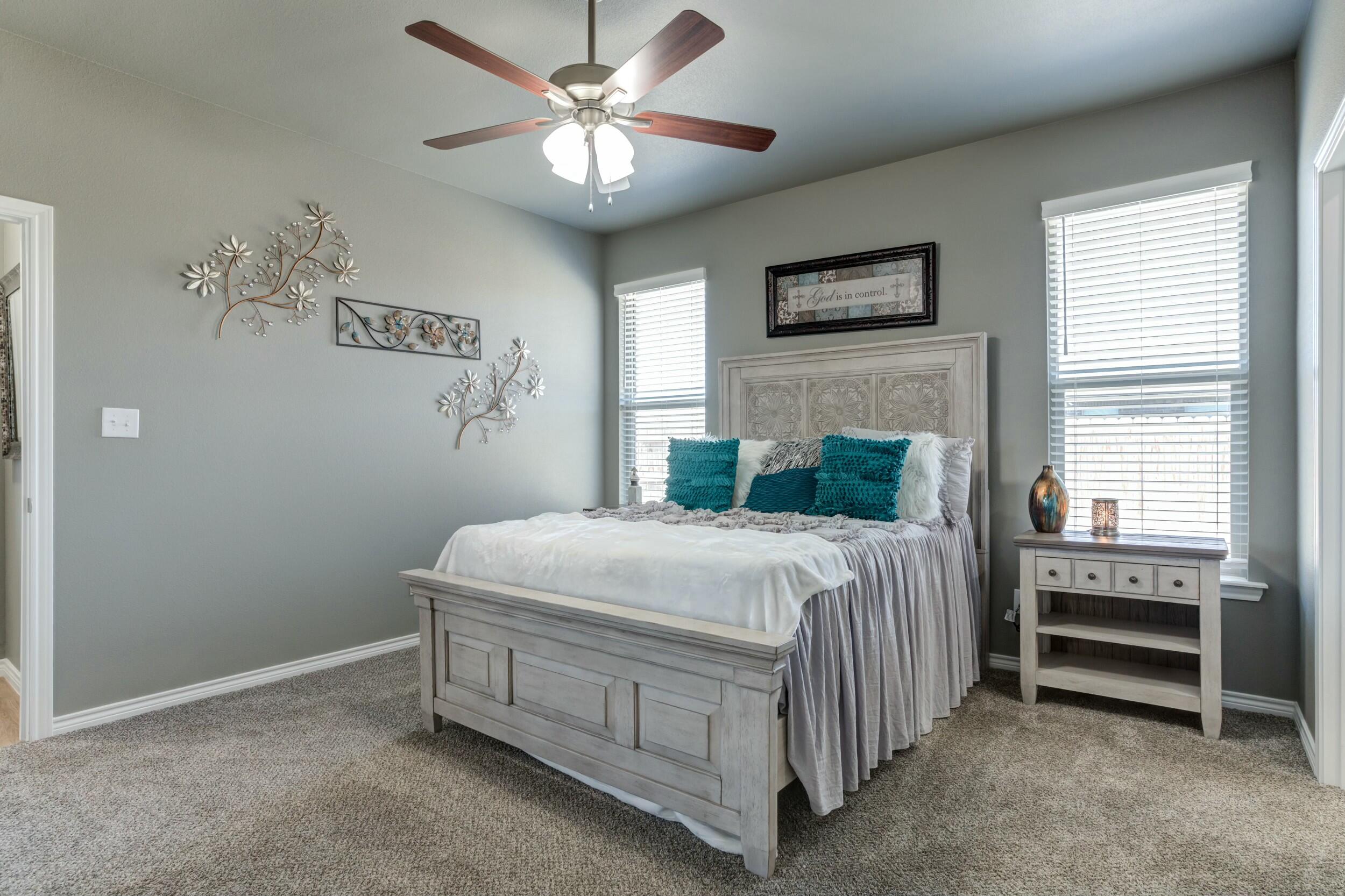 6928 11th Street Lubbock, TX 79416 - Photo 27 of 42 a bedroom with a bed chandelier and a window
