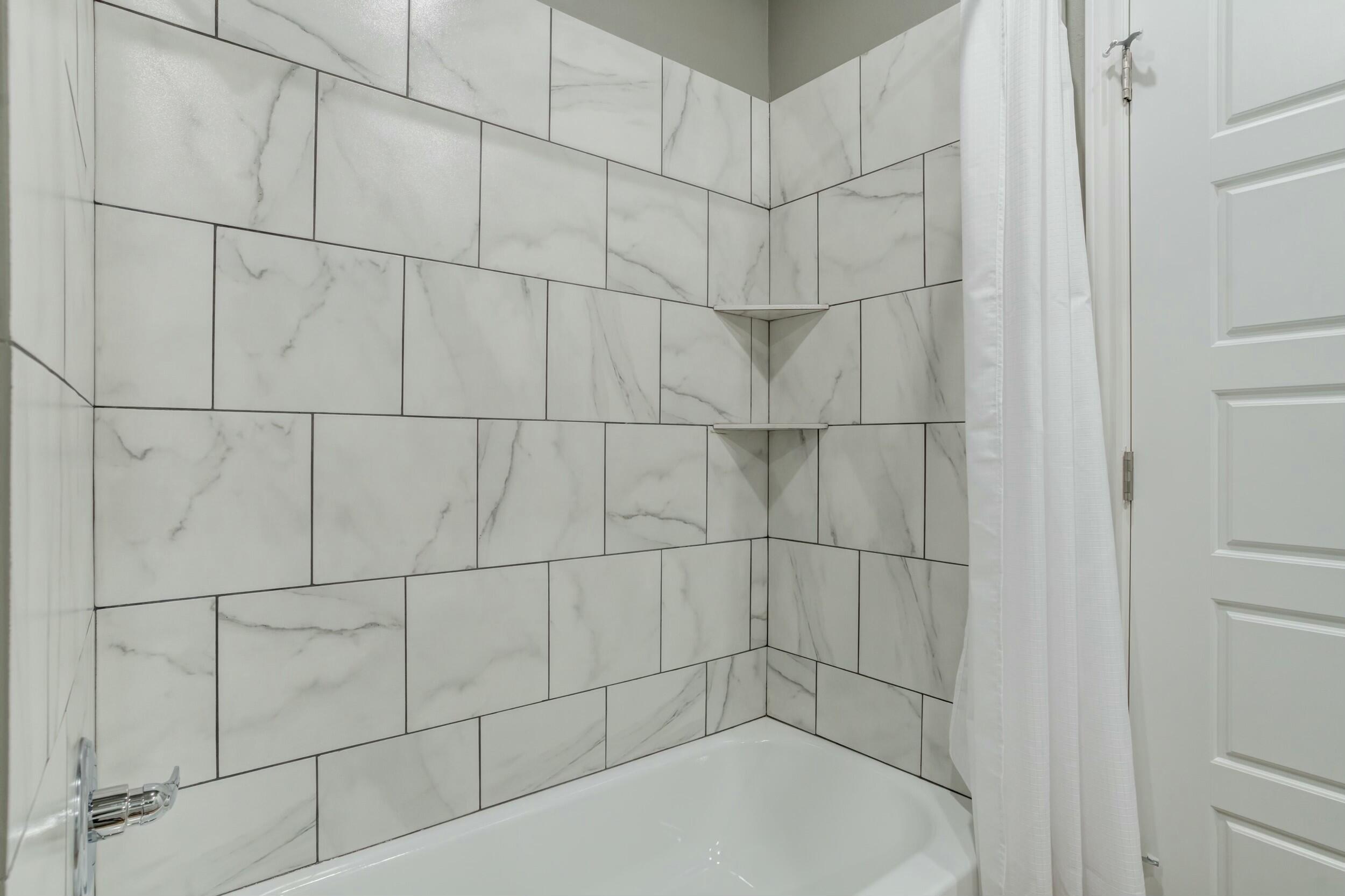 6928 11th Street Lubbock, TX 79416 - Photo 30 of 42 a bathroom with a bathtub