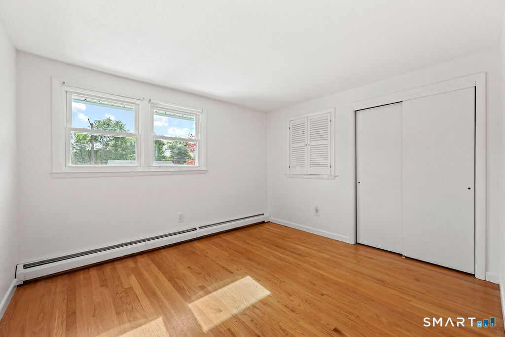 142 Wolcott Hill Road Wethersfield, CT 06109 - Photo 16 of 29 an empty room with wooden floor and windows