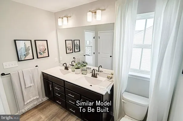 a bathroom with a toilet a sink a mirror and a window