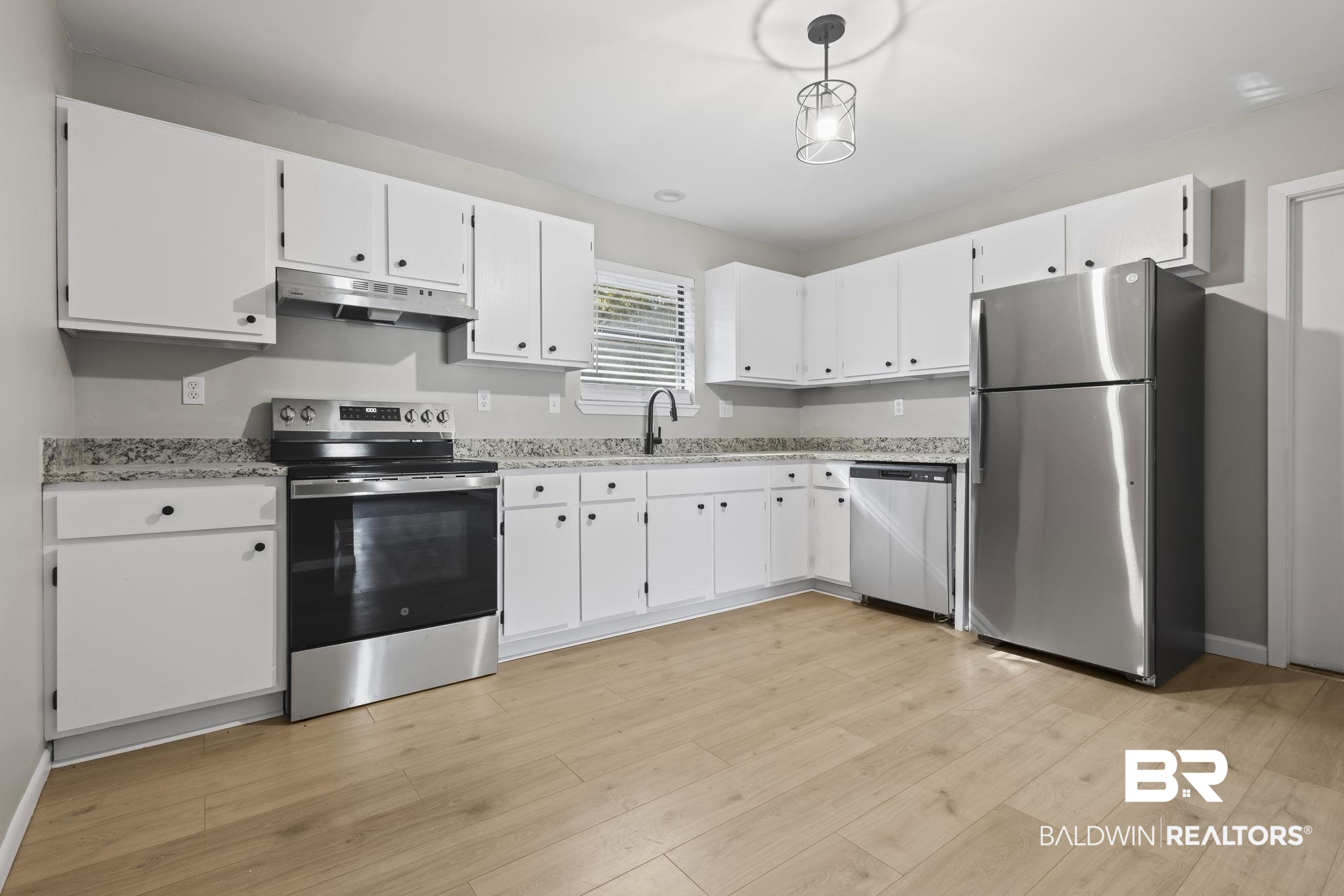 309 West Roosevelt Avenue Foley, AL 36535 - Photo 26 of 60 Kitchen featuring light hardwood / wood-style flooring, white cabinets, hanging light fixtures, and appliances with stainless steel finishes