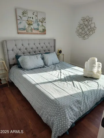 a bedroom with bed and painting on the wall